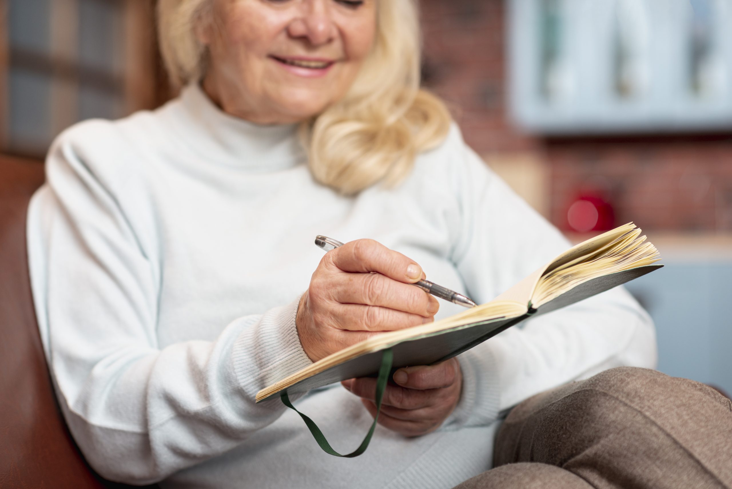 close-up-senior-mujer-escribiendo-en-agenda
