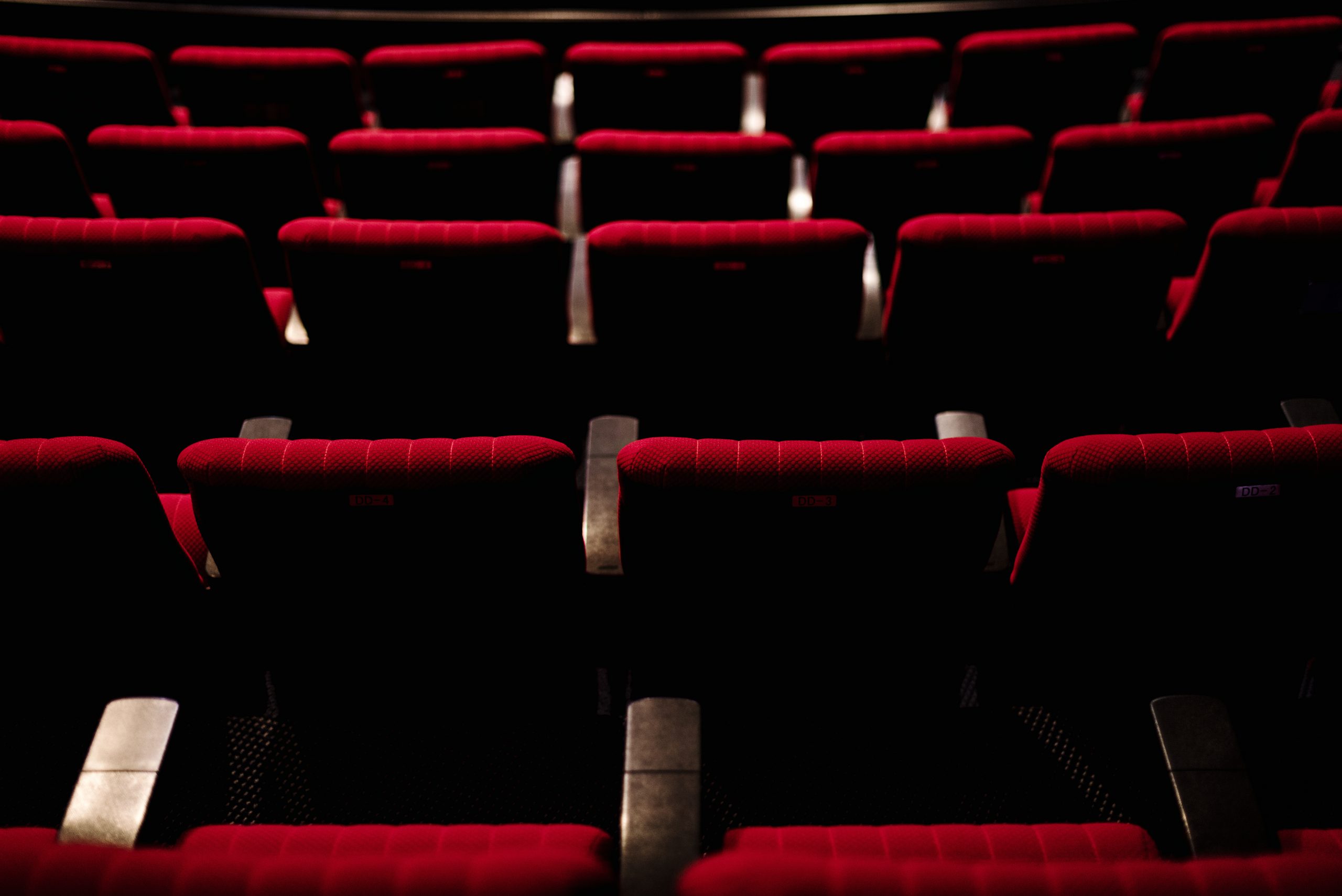 asientos teatro Rows of red seats in a theater
