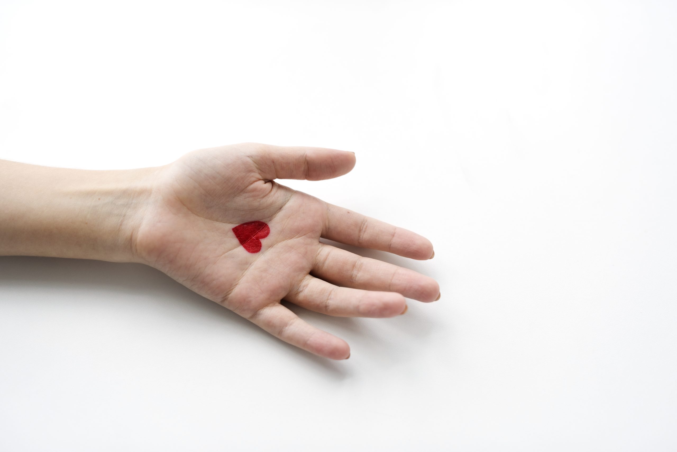 donar sangre Aerial view of heart drawing on hand on white background