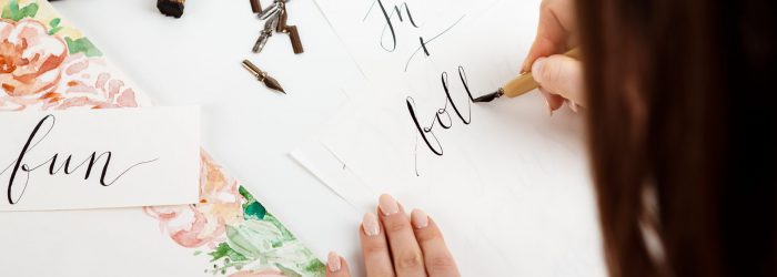 Girl writing calligraphy on postcards. Art design. Copy space.