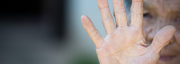close up picture of old woman's hand showing anti symbol
