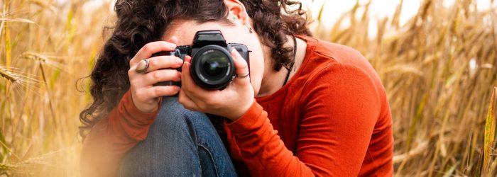 A shallow focus shot of a beautiful young female taking a photo with her camera