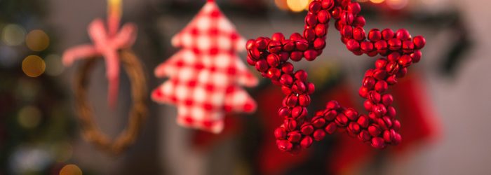 Close-up of christmas ornaments hanging on ribbon at home
