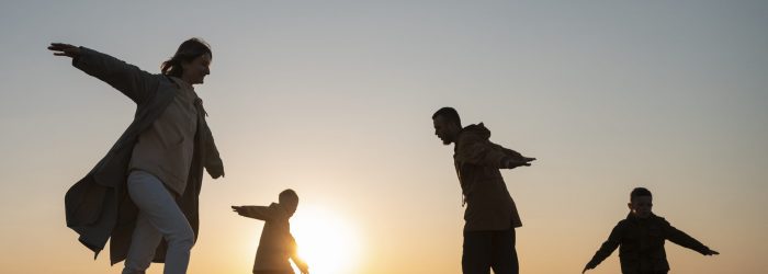 full-shot-family-silhouette-having-fun-sunset