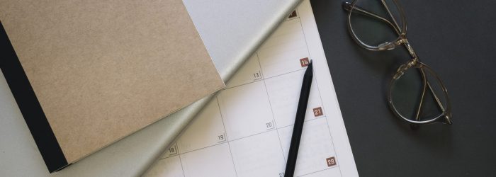 gafas-y-portatil-cerca-del-calendario