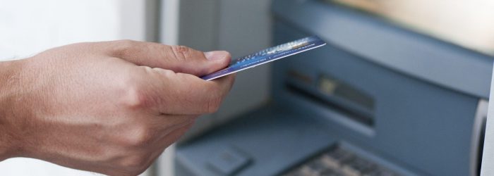 Hand inserting ATM card into bank machine to withdraw money. businessman men hand puts credit card into ATM