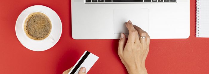 hands-using-computer-holding-card