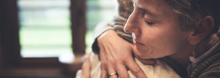 Senior couple embrace in kitchen