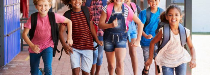 School kids running in elementary school hallway, front view