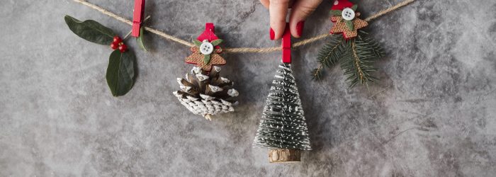 mano-que-sujeta-adornos-navidenos-en-hilo