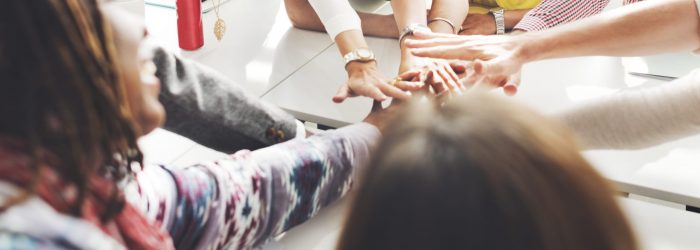 People with joined hands as a team