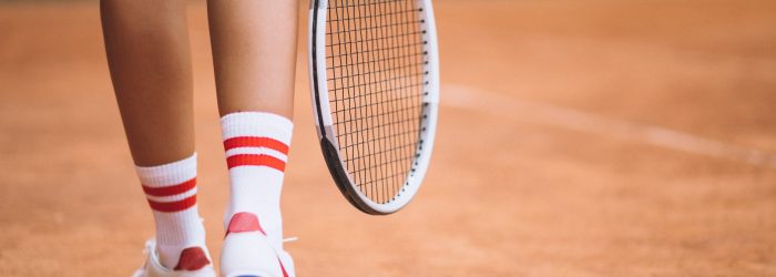 Young female tennis player at the court, feet close up